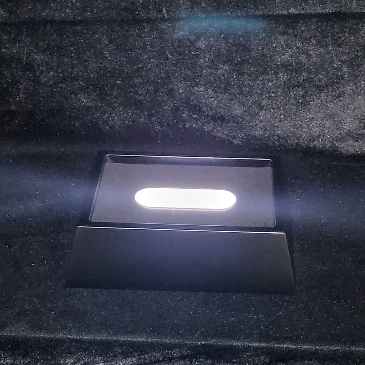 Lit LED light base for 3D photo crystals, shown on dark fabric